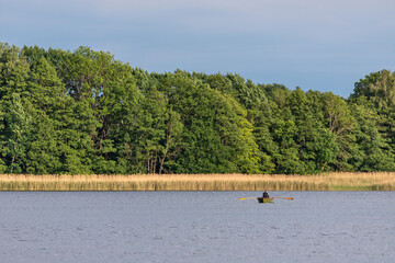 angler in a rowing boat on Lake Krakow in the Mecklenburg Lake District, Germany