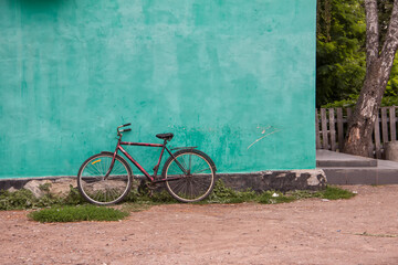 Red bicycle on a green wall