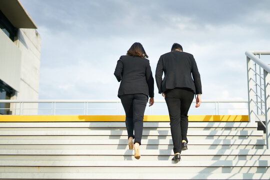 Business colleagues walking up stairs outdoors
