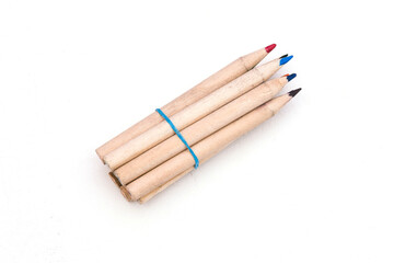 Multi-colored pencils held together with an elastic band, isolated on a white background with a copy of the space.