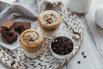 Dalgona whipped coffee, instant, cream, iced coffee. Cocktail with coffee, milk and ice cubes on white background mockup. Trendy drink background with copy space for text.