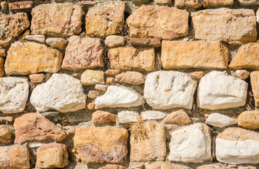 A wall of ordered sea stone on the edge of the beach 