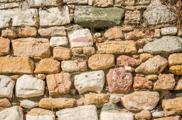 A wall of ordered sea stone on the edge of the beach 