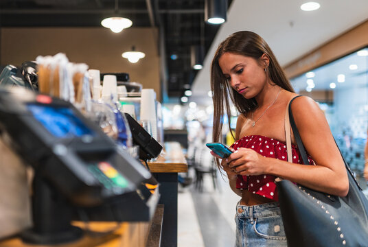 beautiful brunette paying with phone.