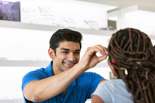 Eyewear: Male Clerk Assists Woman With Trying On Frames