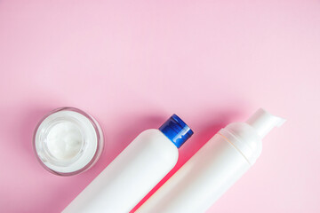 Set of cosmetics for skin care and cleansing on pink background. The concept of purity and body health. Place for text.