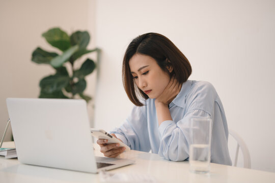 Thinking asian woman using a mobile phone and laptop
