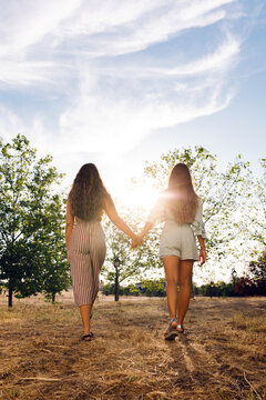 two girls holding hands in the forest