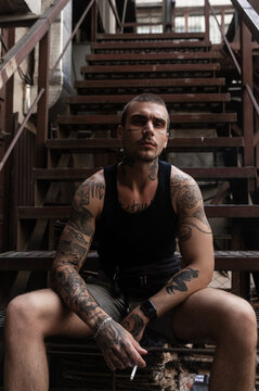 Modern guy smoking on stairway