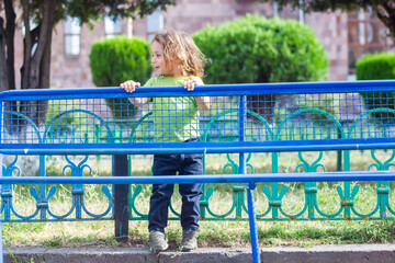 happy little boy playing in the park, long hair boy in the park