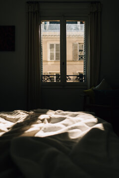 Bed with view of Paris apartments through the window