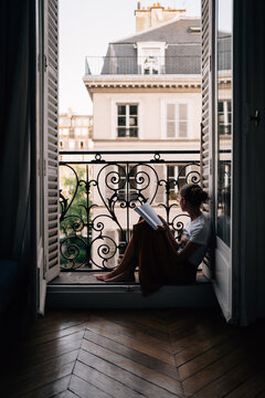 Girl reads while looking at Paris