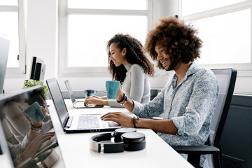 Side view of two african coworkers working together in creative