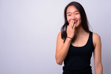 Portrait of happy young beautiful Asian woman