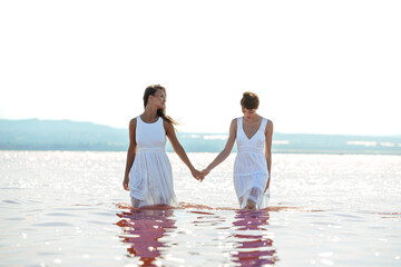 cute Women walking on a amazing pink lake holding hands