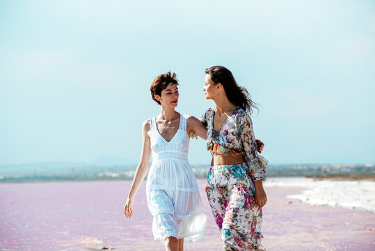 cute Women walking on a amazing pink lake holding hands