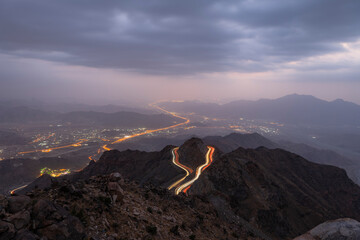 Traffic light trails wrapped around mountain on the zig zag road in Al Hada, Taif region of Saudi...