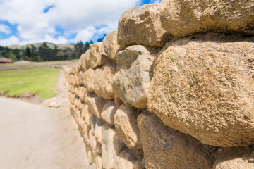 Inca wall in the archeological site of Ingapirca, Ecuador. White clouds and blue sky on the background
