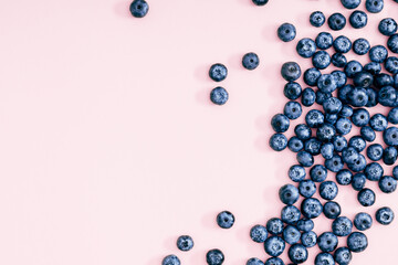 Fresh berries blueberry on pink background. Colorful fruit pattern of blueberries as background. Creative berries concept. Flat lay, top view, copy space