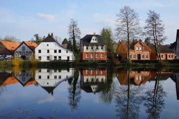 Obraz premium Spiegelung eines See mit Häusern in einem Ort