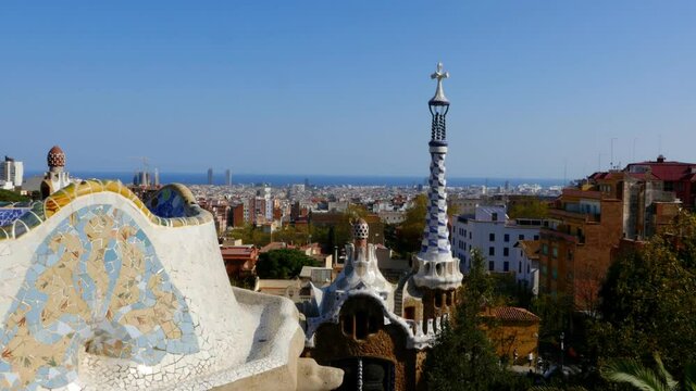Ceramic tiles, houses in Antoni Gaudi's Park Guell and view to Barcelona, Spain