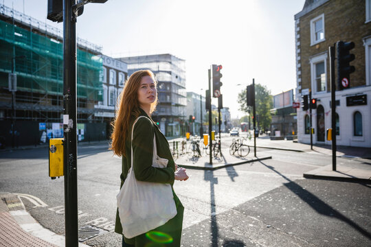 Young woman waiting at the traffic light