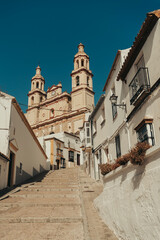 Old white town with church centered on the road.