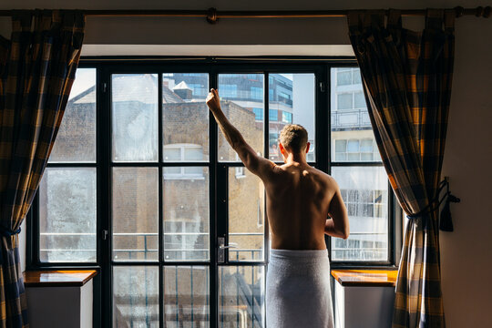 Adult man enjoying the sun rays besides the window in the morning