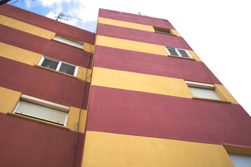 Fototapeta na wymiar Facade of a building painted in red and yellow stripes