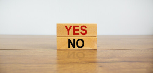 Wood blocks with words 'yes, no' on wooden table. Beautiful white background, copy space. Business concept.