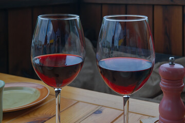 Two glasses with dry red wine on a table in a cafe close-up.