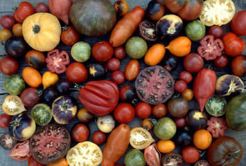 Multicolored tomatoes on a wooden surface top view, selective focus.
