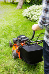 Gardening. Mowing a lawn with a petrol lawnmower.