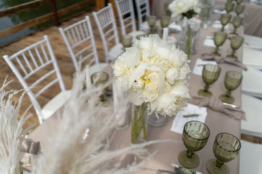 Decorated wedding table, white peonies and feathers. Chiavari chairs are at the table-2.