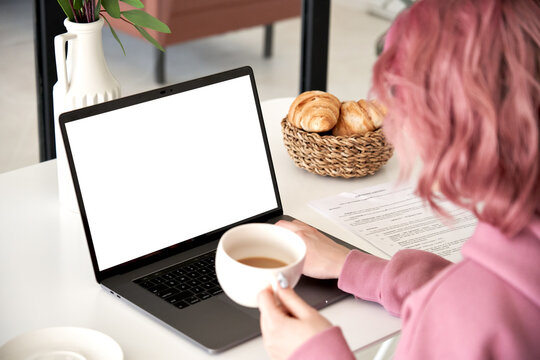 Hipster Teen Girl Young Woman Student Worker Freelancer Sit At Kitchen Table Using Laptop Mock Up White Screen Drink Coffee Learn Online, Work From Home Office, Paying Bills In App. Over Shoulder View