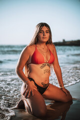 Obraz premium Chica rubia playa bikini rojo españa negro brasileño pose natural rocas verano vacaciones
