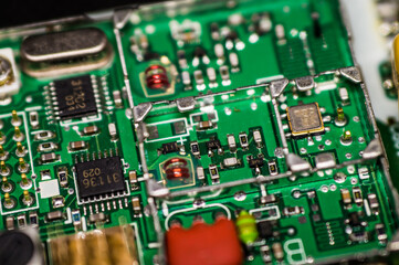 A microcircuit with transistors, resistors, capacitors, coils, contacts on an electronic board in an enlarged form.