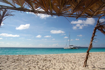 Beautiful panorama of an heavenly beach with white sand beach, turquoise blue water sea and a white sailing catamaran boat, Seychelles. La Digue, Mahe, Praslin.
