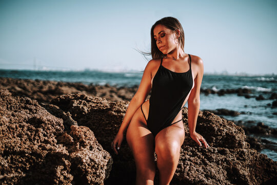 Chica rubia playa bikini rojo negro españa negro brasileño pose natural rocas verano vacaciones