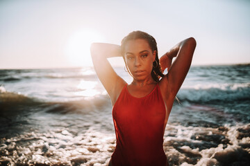 Fototapeta na wymiar Chica rubia playa bikini rojo negro españa negro brasileño pose natural rocas verano vacaciones