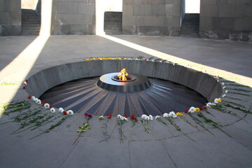 Flame Fire in the Armenian Genocide memorial with beautiful red and white flowers, Genocide Museum, Armenia.