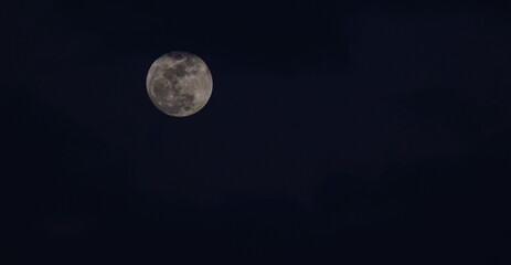 luna junto a nubes cielo azul de noche 