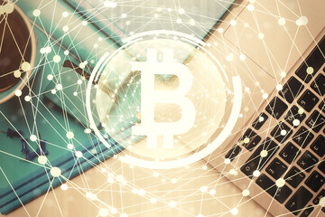 Blockchain theme hologram drawings over computer on the desktop background. Top view. Multi exposure. Concept of cryptoeconomy.