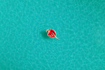 Young happy woman with inflatable ring in swimming pool, top view. Summer vacation