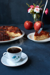apple pie with kitchen cutlery and coffee on a dark base with natural light