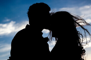 Silhouettes of people, with the sun in the background.