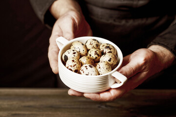 A man holding a pot of quail eggs.