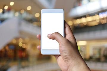 Hand of a man holding smartphone device in the blur Shopping mall background.