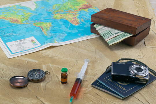 vaccine for covid-19 with elements to travel, maps, money, camera