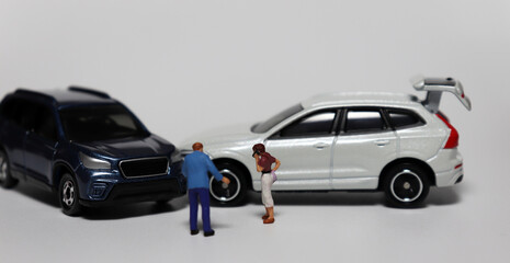 Drivers Arguing After Traffic Accident. Miniature people and miniature cars. 
